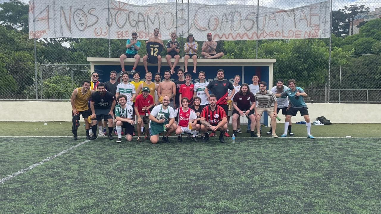 Elenco completo do ADL posa no campo sob a faixa pintada à mão