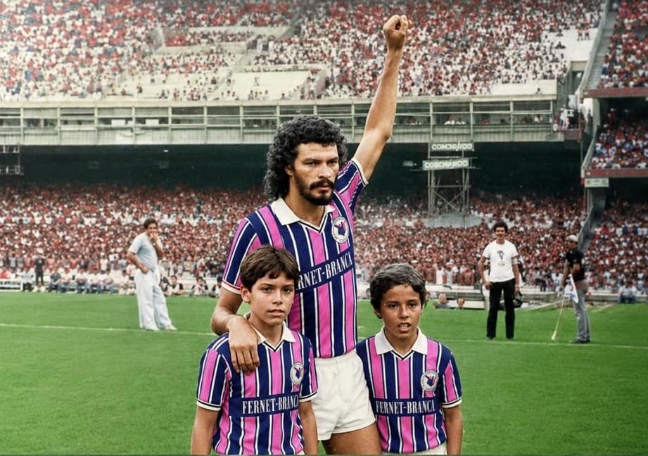 Capitão levanta o punho no estádio lotado com a camisa listrada